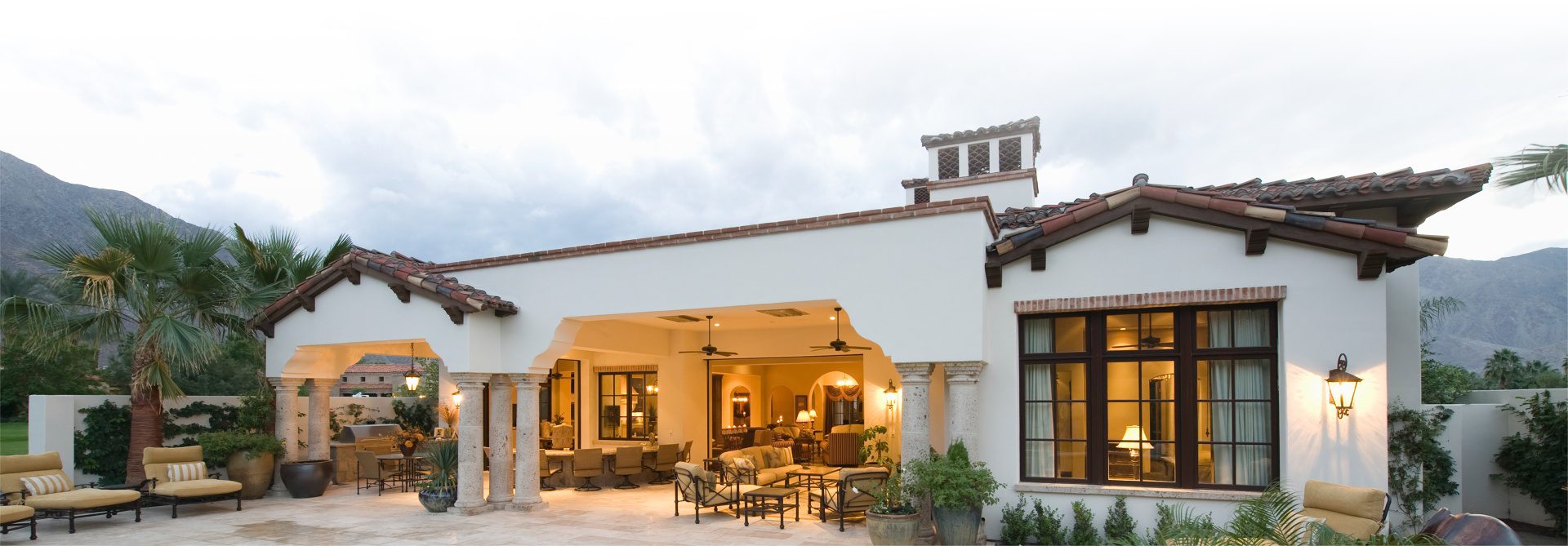 A large patio with chairs and tables outside of it