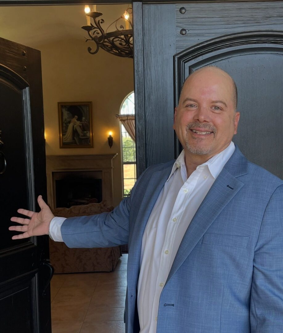 A man in a suit standing next to a door.